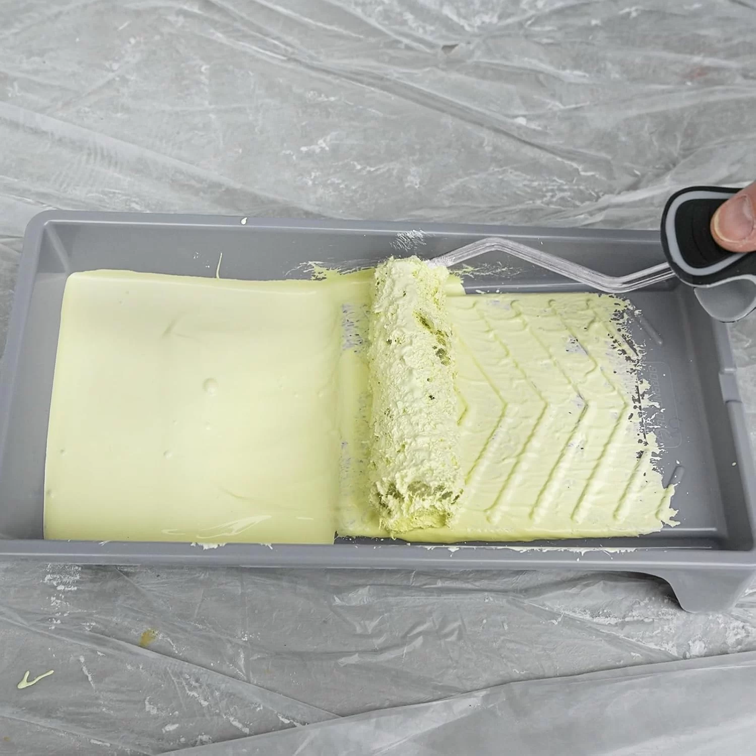 Paint roller applying the W-pattern stroke across a wall section for even coverage