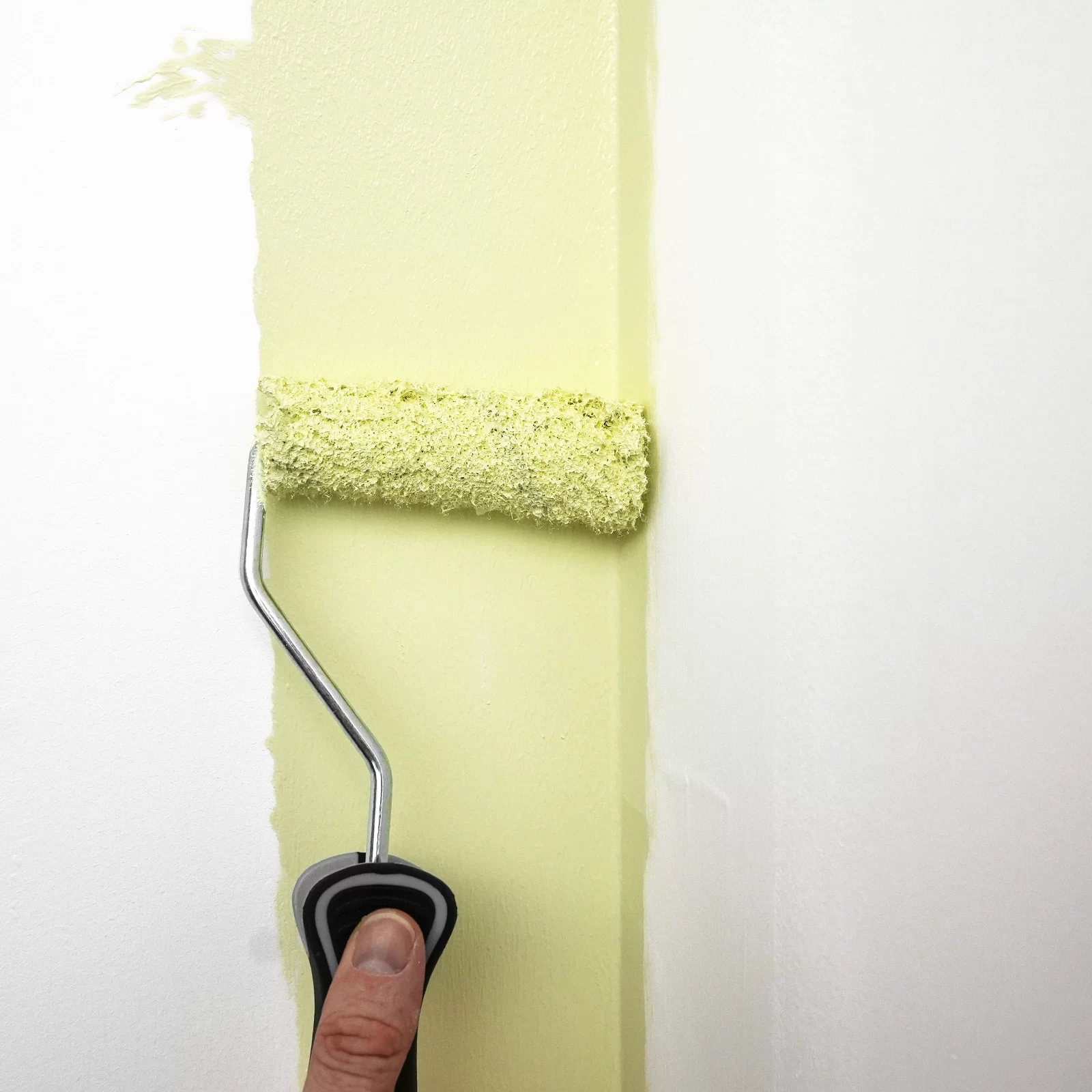 Paint roller applying the W-pattern stroke across a wall section for even coverage