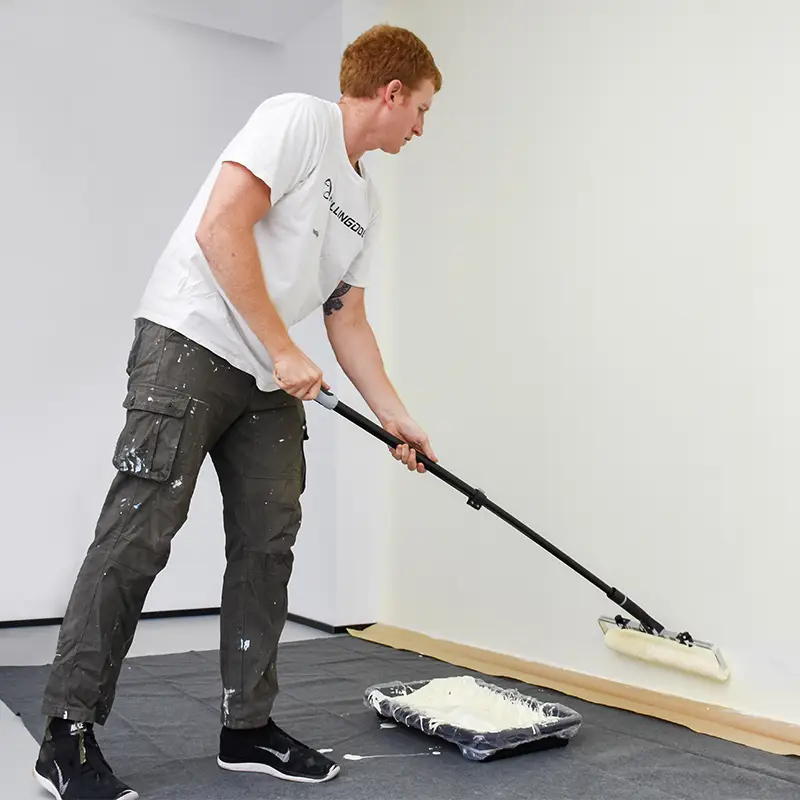 Painting a wall in a W pattern with a roller for even coverage